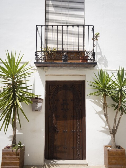 Ornate wood door and balcony in sunny urban settin 2026 03 18 16 17 34 utc